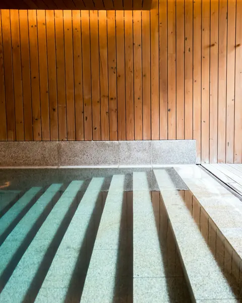 Marches d’un bassin d’eau claire sous un plafond de lattes de bois